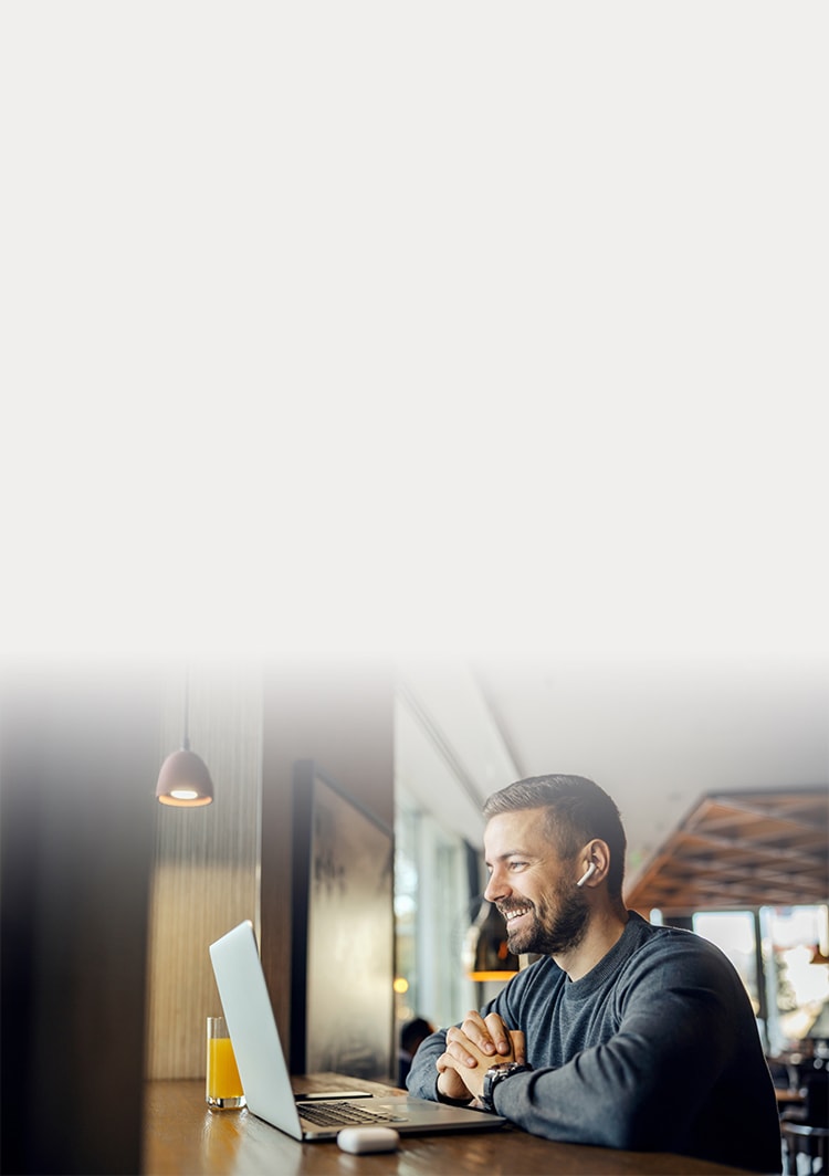 Hombre sonriente usando ordenador portátil